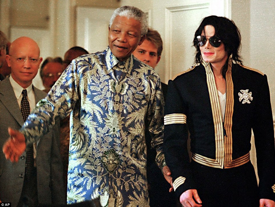 #27 South African President Nelson Mandela, left, and American pop singer Michael Jackson arrive at a news conference in Cape Town in 1999.