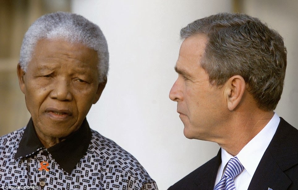 #28 U.S. President George W. Bush looks up at former South African President Nelson Mandela as they address the media gathered outside the Oval Office of the White House November 12, 2001.