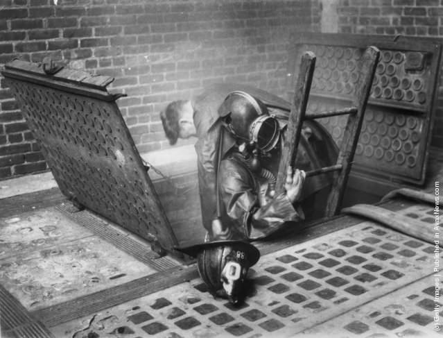 #20 Two firefighters emerging from a smoke-filled vent, 1929.