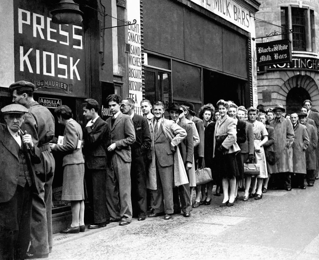 #21 Queues of people wait in Fleet Street during a cigarette shortage.