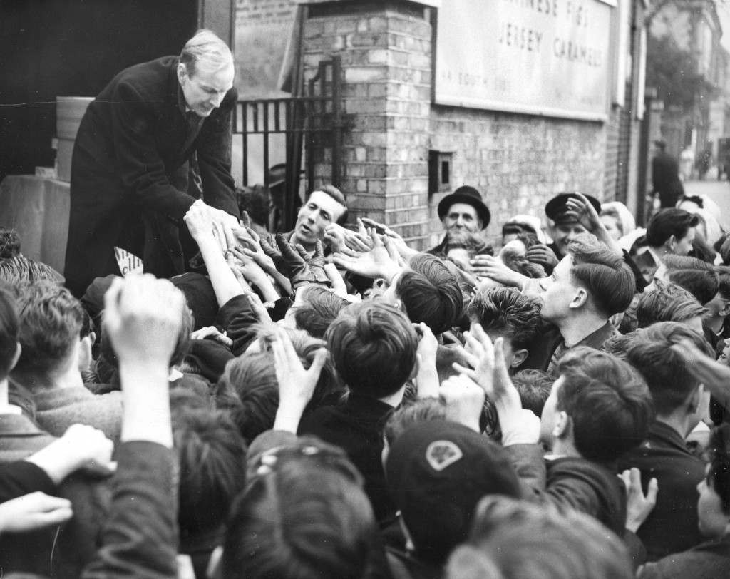 #6 Eager hands of London children stretch out for sweets being distributed for free, 1954.