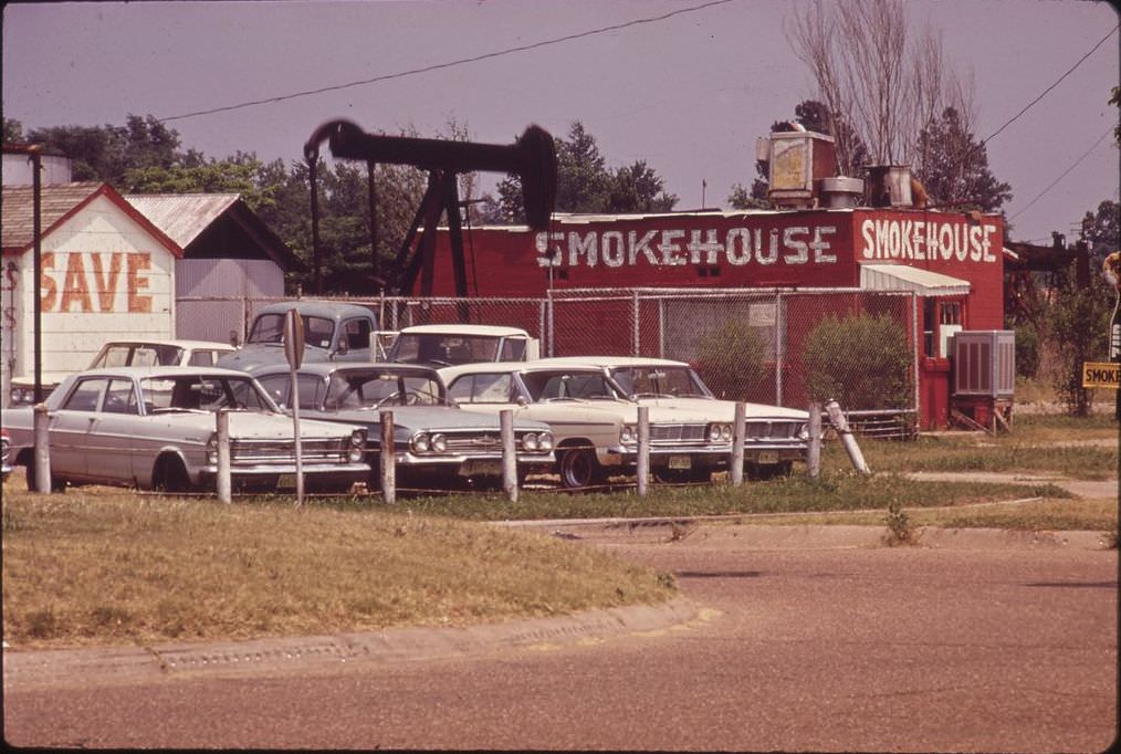 #30 An oil derrick beside a restaurant and used car lot, [Date unclear, removed].