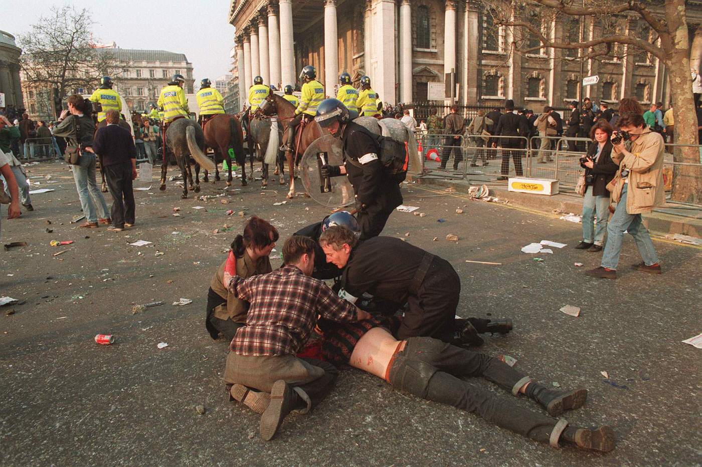 #63 An injured protester during rioting after an anti-poll tax demonstration in Trafalgar Square, 1990.