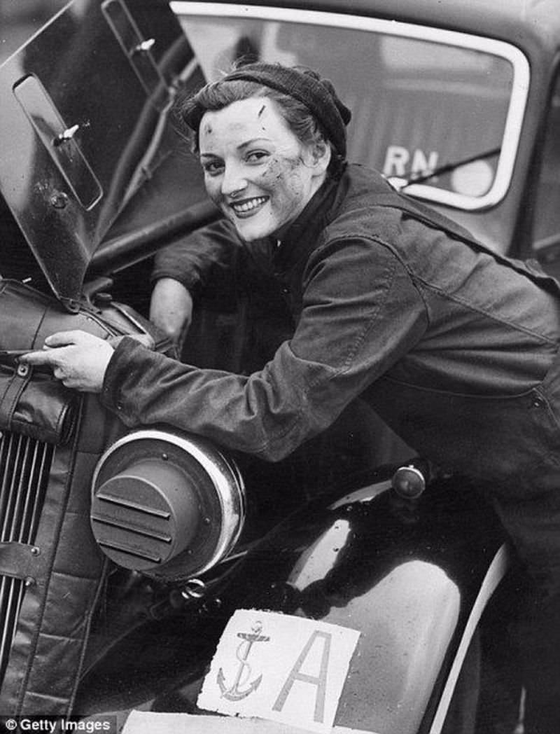 A motor transport driver from the Women’s Royal Navy Service, repairing the engine of her car, 1943.