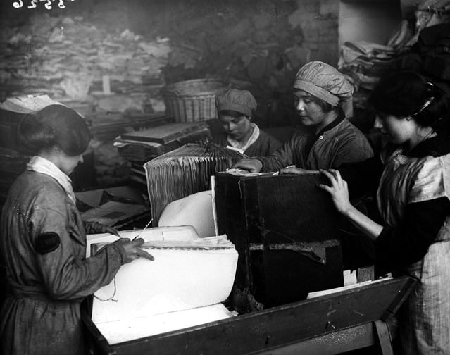Women pulling apart old ledgers for the London &; South West Railway, 1917.