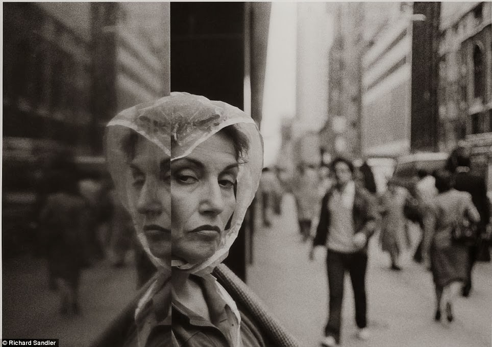 #2 A woman wearing a rain hat peers distrustfully at the camera lens as she stands in a doorway on Fifth Avenue, 1984.