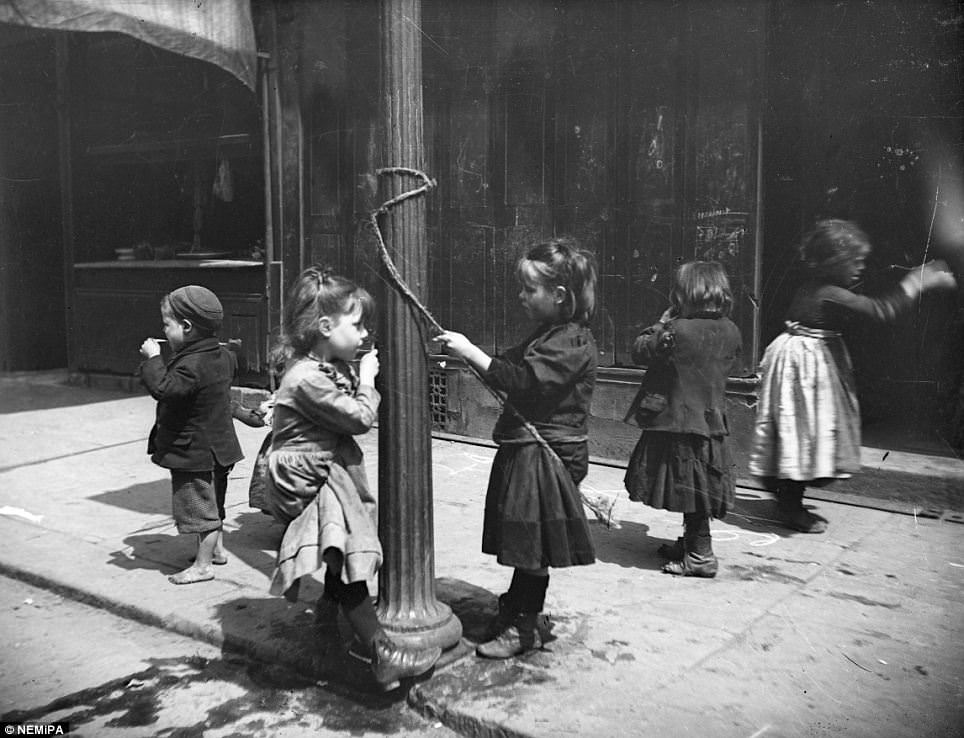 #8 Children skip and play around a lamp post.