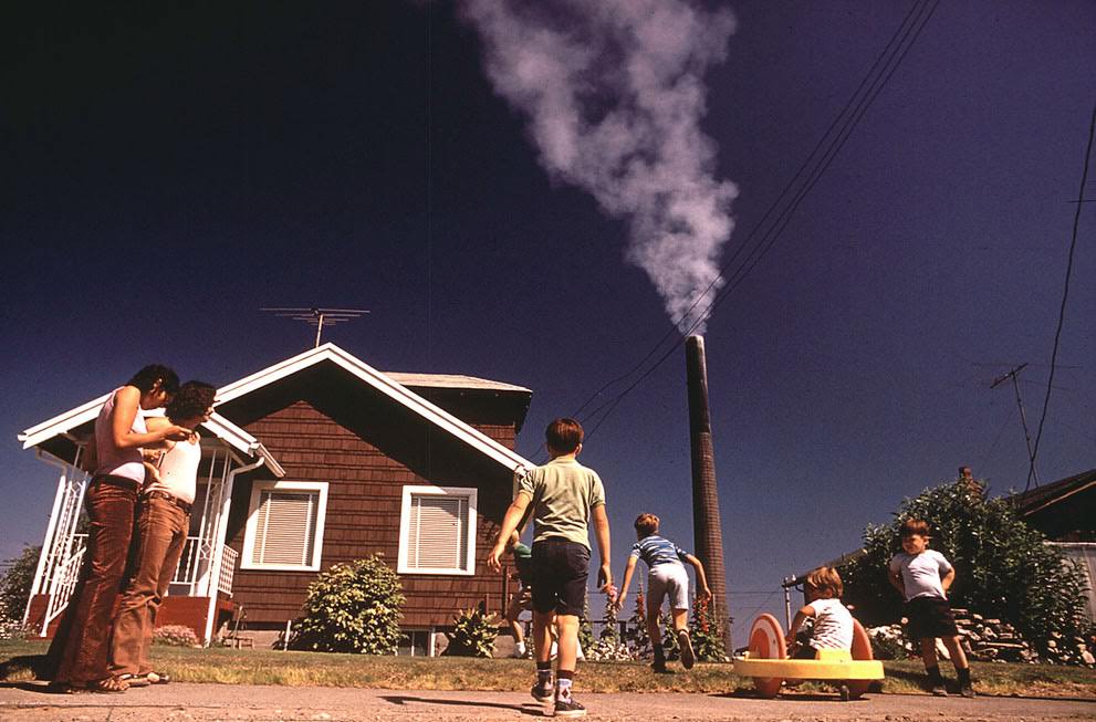 #23 Children play in the yard of a Ruston, Washington home, while a Tacoma Smelter stack showers the area with arsenic and lead residue, 1972.