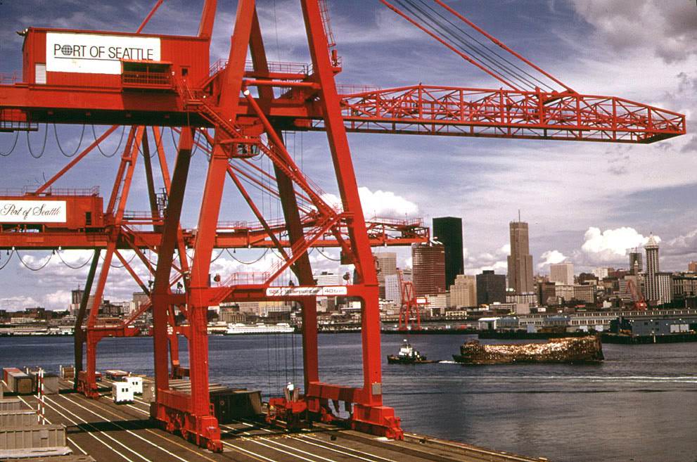 #9 Port of Seattle freight handling equipment and city skyline, with an industrial waste barge under tow to landfill on the Snohomish River estuary.