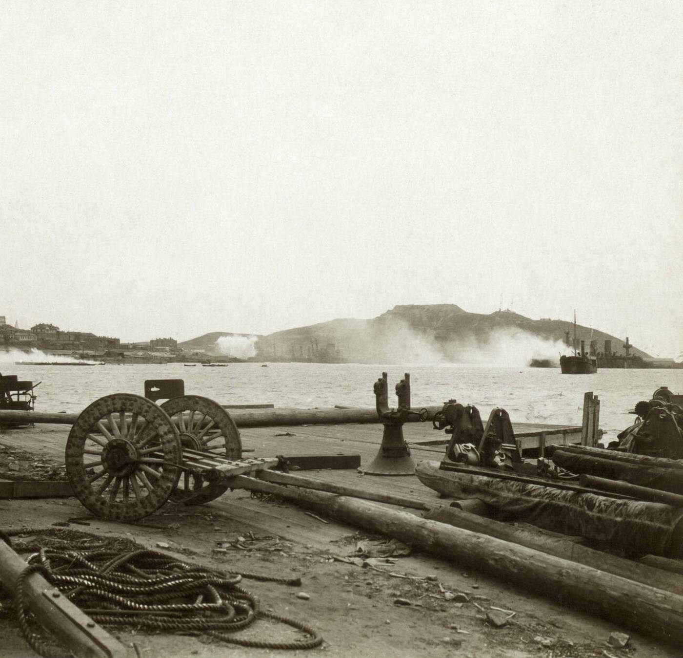 Japanese forces firing shells on Russian battleships in the Bay of Lushun, Port Arthur, China, 1905.