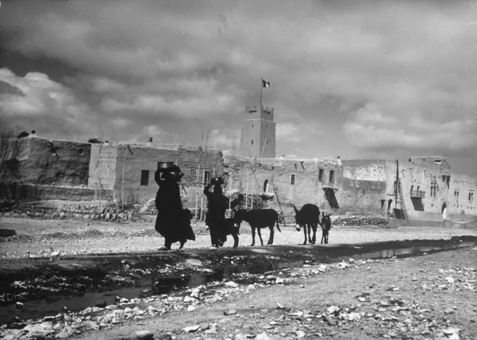 #2 Women carry water containers on their heads as they lead mules along a road in a desert village near Damascus, Syria, 1940.