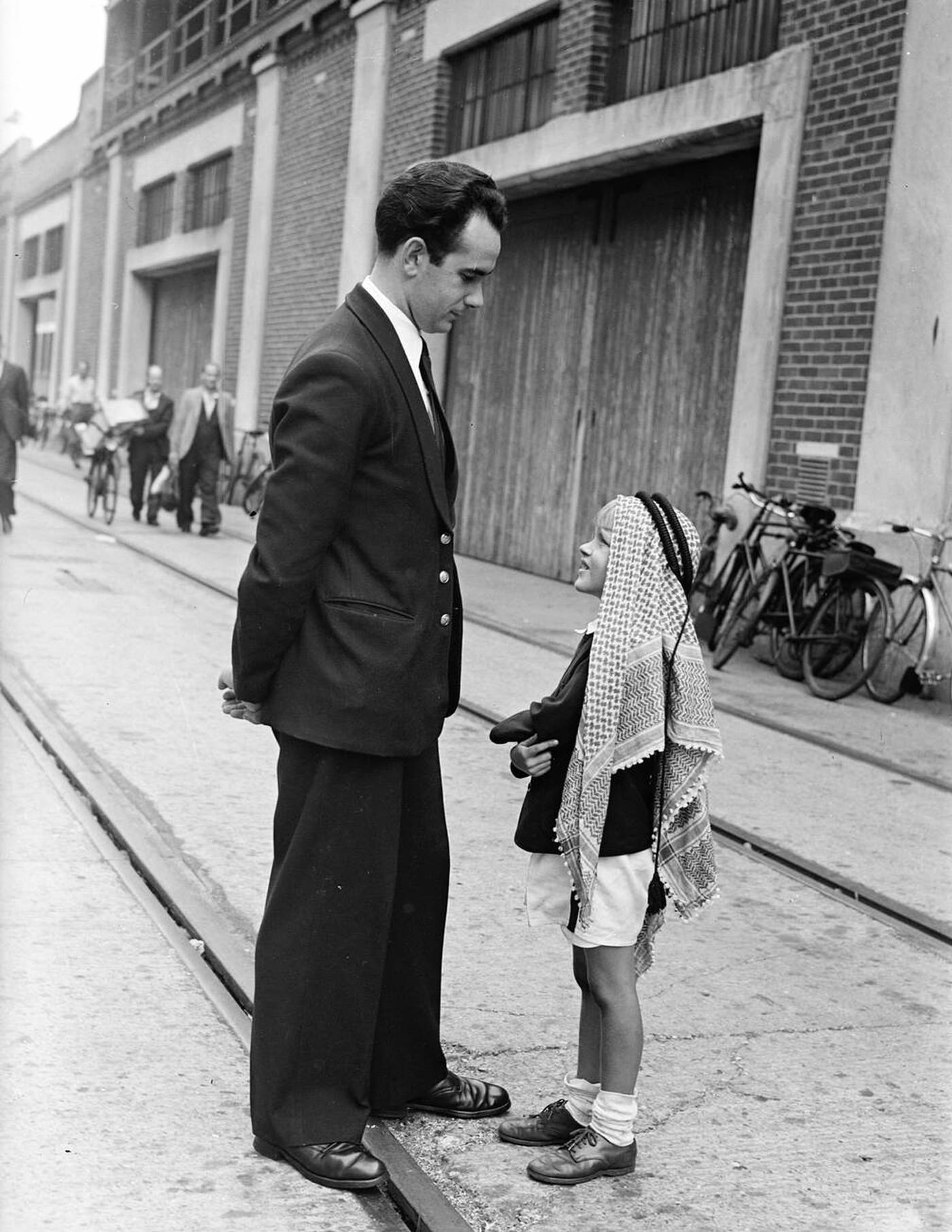 #24 [Factually Corrected] Tweedie Roosevelt, wearing the national head-dress of Syria, waits to board the “Caronia” to sail for Long Island, New York, 1949.