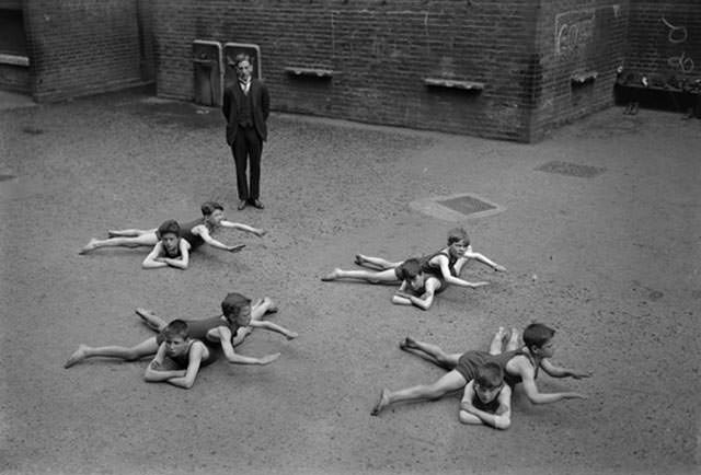 Schoolyard children learning how to swim despite their lack of access to water, 1922.