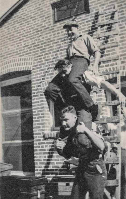 Three young men riding on each others’ shoulders.