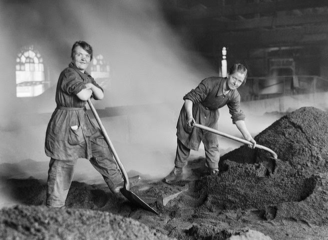 Women workers feed a charcoal kiln used for purifying sugar at a refinery in Scotland during the First World War.