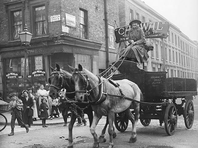 A woman driving a wagon and horses in north London, 1916.