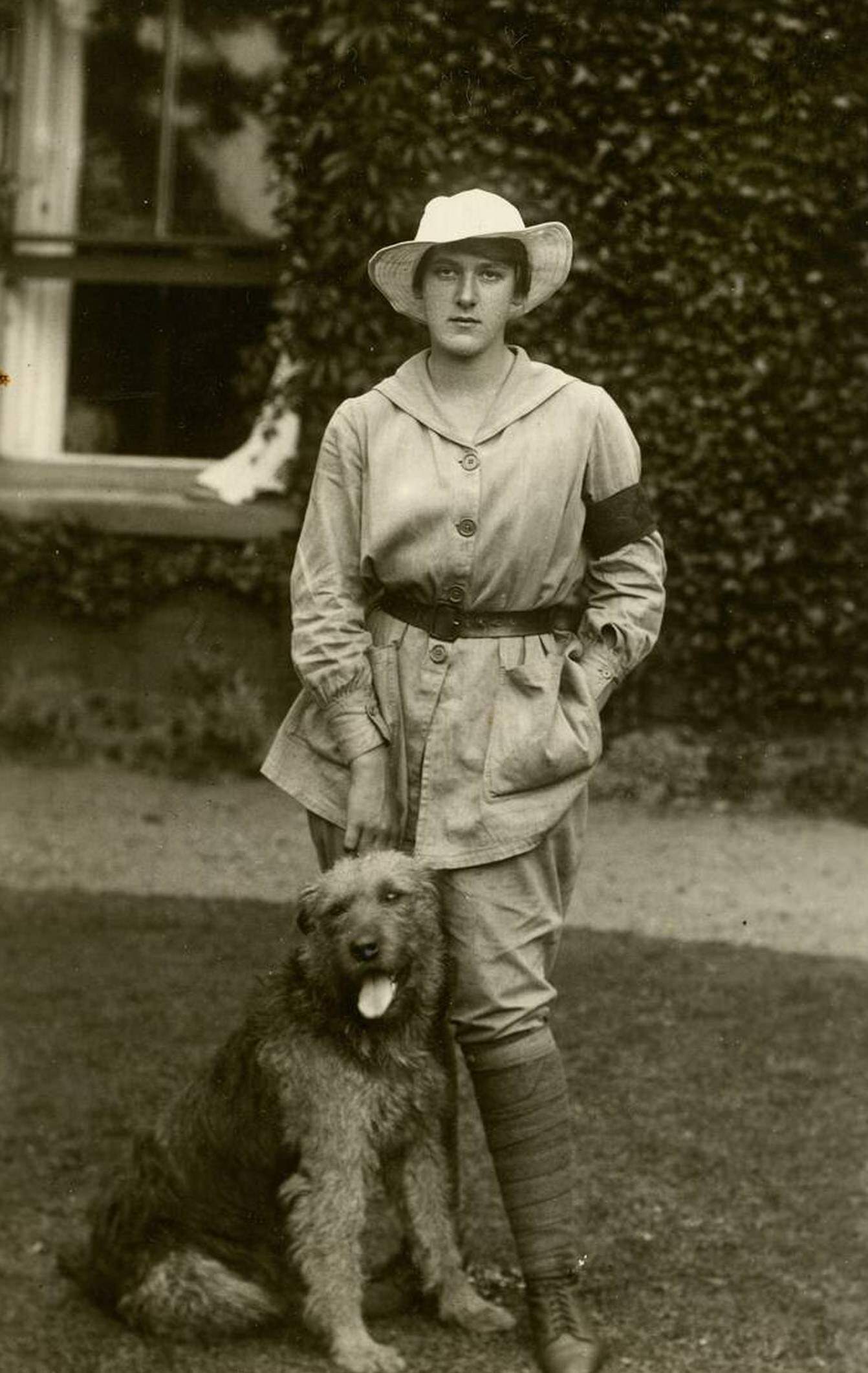 A land girl called Esme Greene wearing a beige tunic and a 3-month service armband, 1917.