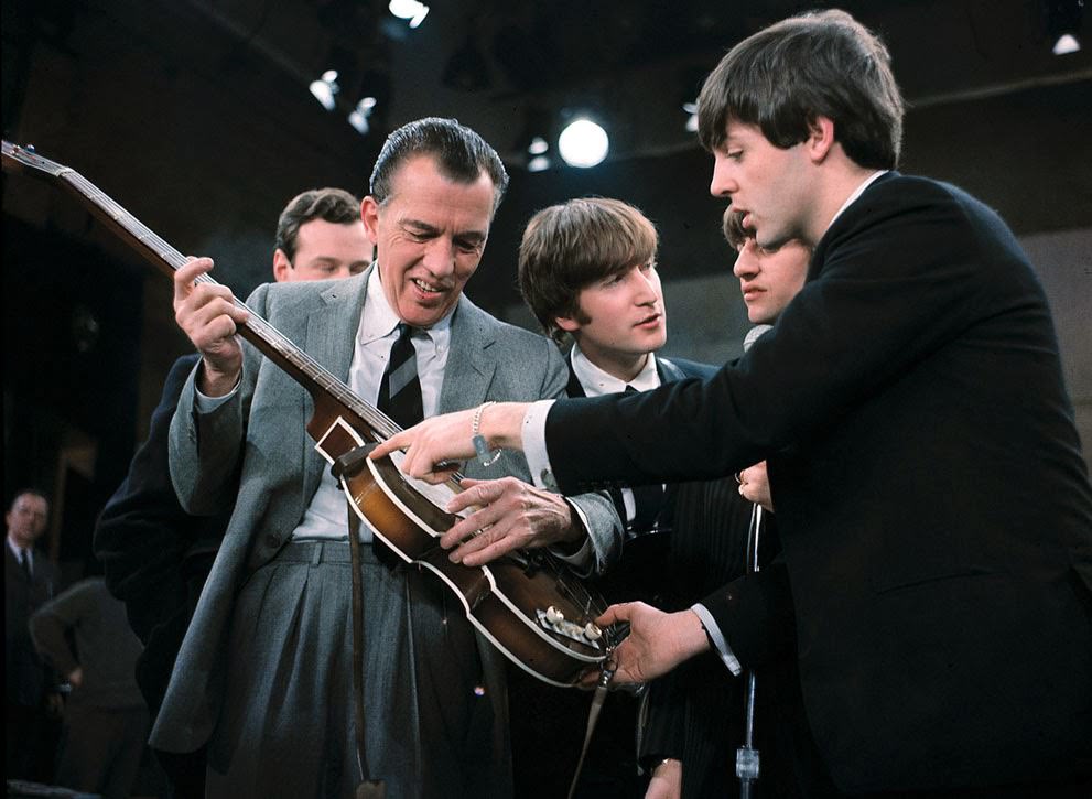 Paul McCartney shows his guitar to Ed Sullivan before the Beatles’ live television appearance in New York; Beatles manager Brian Epstein, John Lennon, and Ringo Starr are behind Sullivan, 1964.