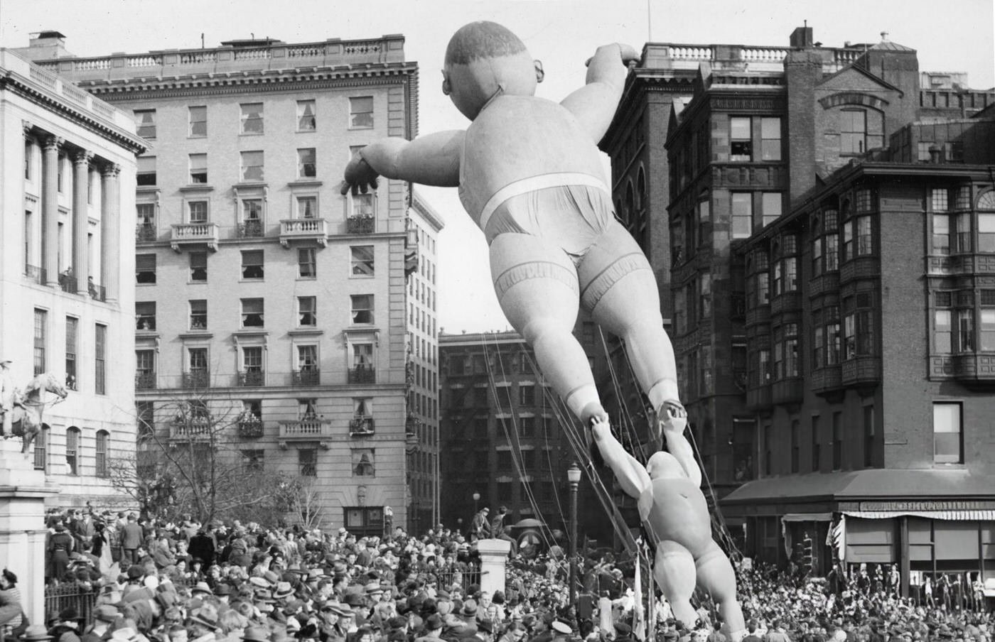 #21 Acrobat balloons float past the Massachusetts State House during the annual Santason parade in Boston, 1941.