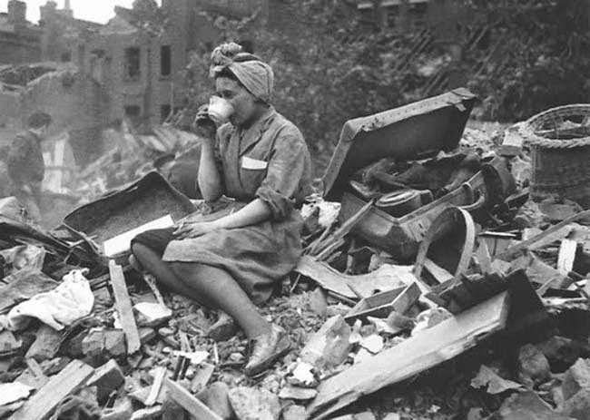 #23 A woman drinking tea in the aftermath of a German bombing raid during the London Blitz, 1940.