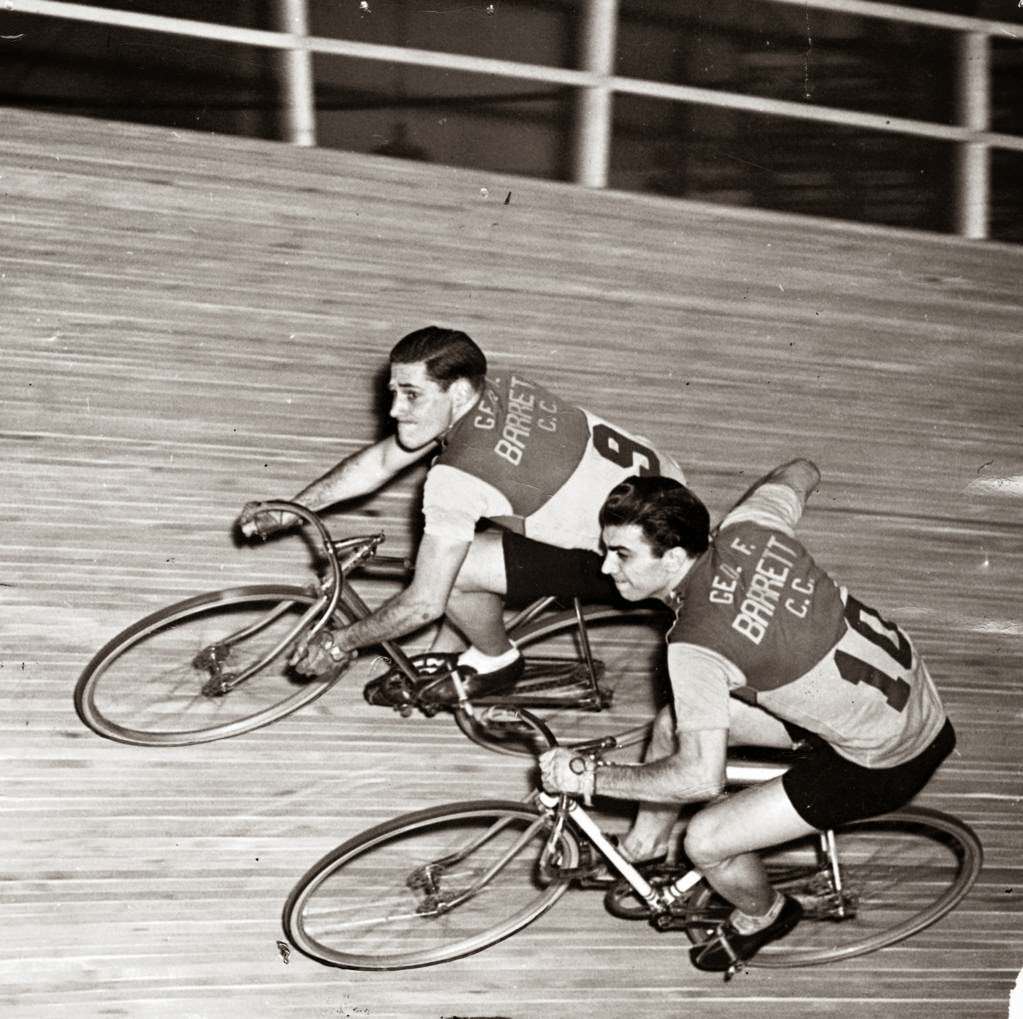 Bill Jacoby and Ed Carfagnini, a team of Chicago’s youngsters, maintain their equilibrium during a six-day bicycle race at the Coliseum; Carfagnini is giving Jacoby a push as the latter takes over for the team, 1942.