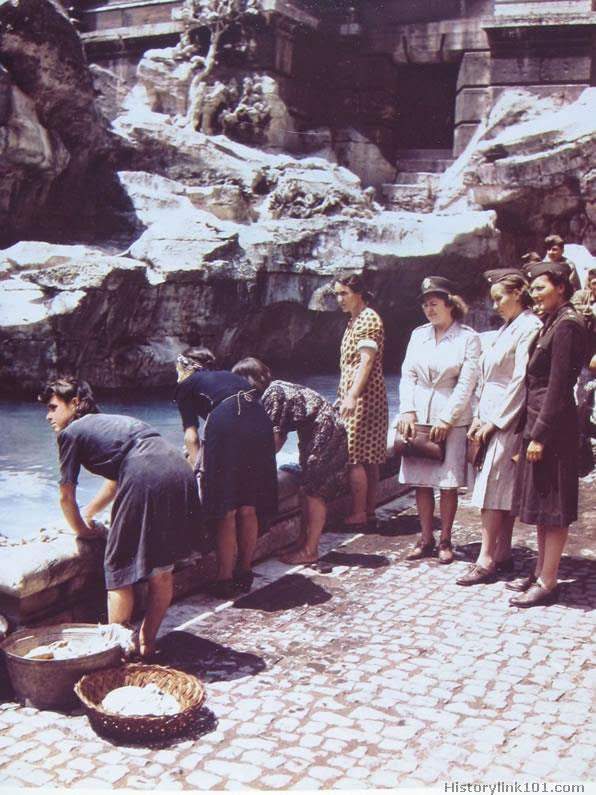 Italian women wash clothes at the fountain of Fontana Verdi while US Army nurses and GI’s look on. June 1944.