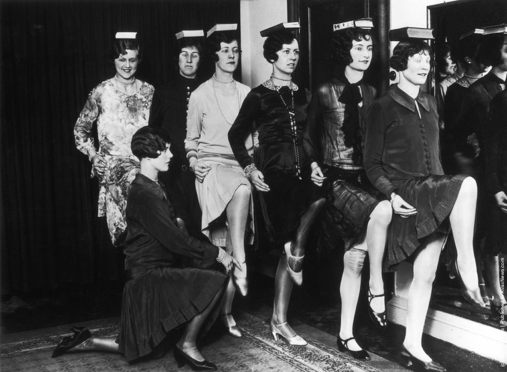 #3 Trainee fashion models learn how to carry themselves gracefully by balancing books on their heads at a school of modelling and deportment in the West End of London, 1925.