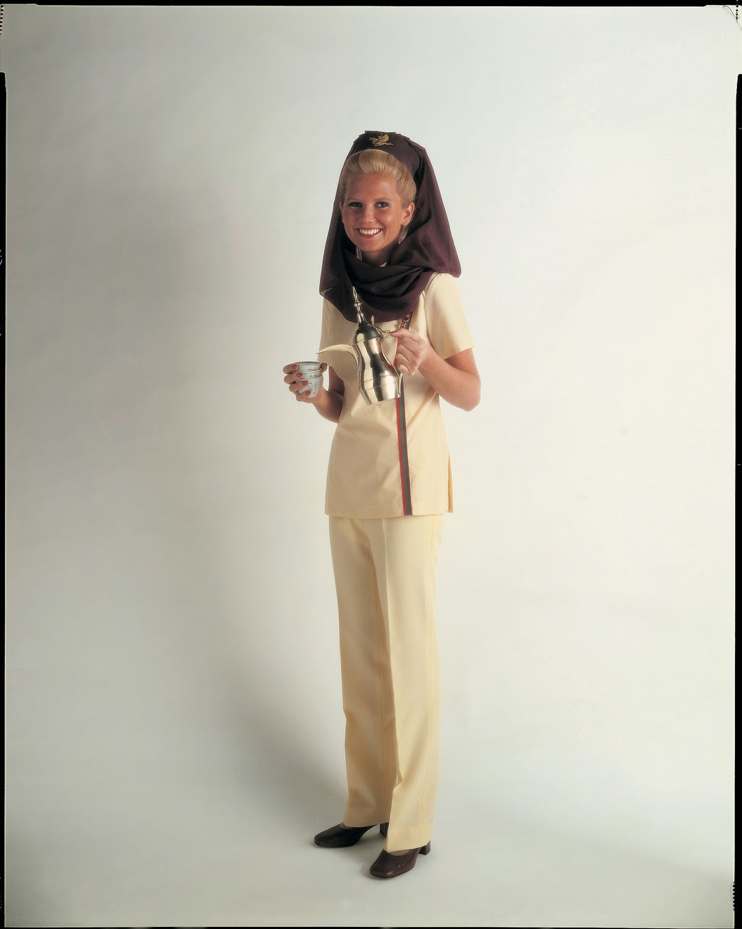 Middle East meets West in the 1970s with Gulf Air’s adaptation of the Muslim headdress; legs are covered by smart trousers. The uniform was originally designed by Joy Stokes.