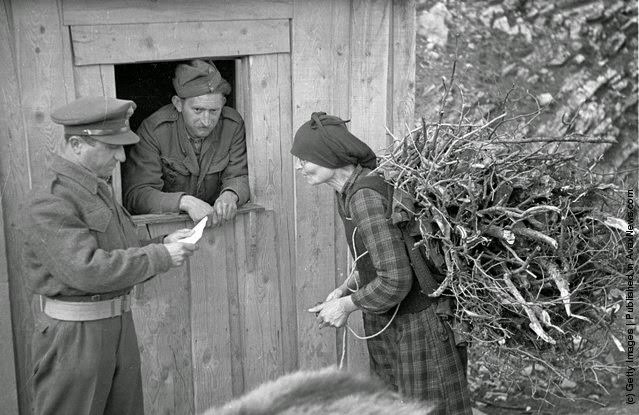 #15 A Greek woman checks in with the village patrol for the evening curfew during the Greek Civil War, 1948.