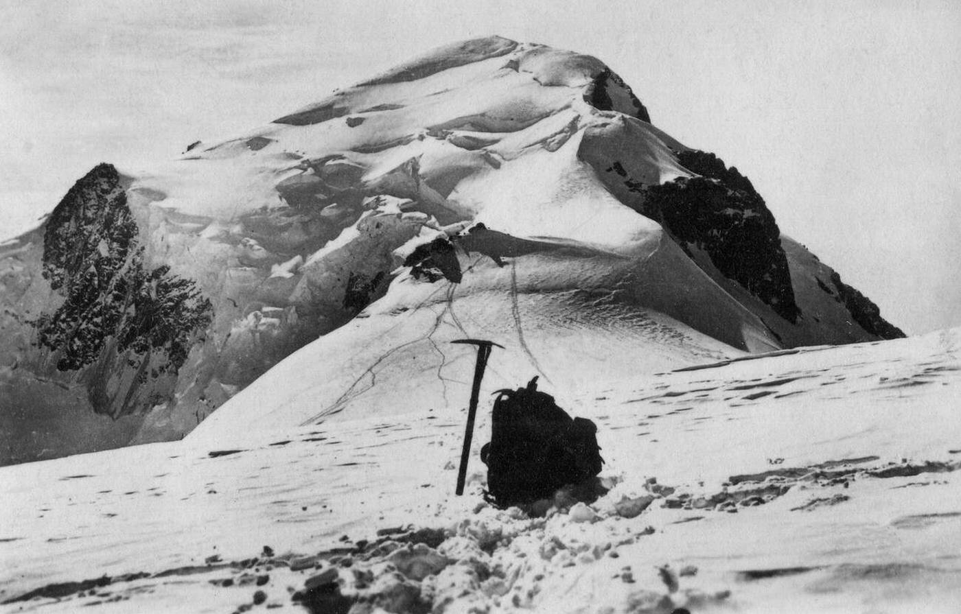 #33 The mountain Mont Blanc with an ice axe and knapsack in the foreground, 1930s.