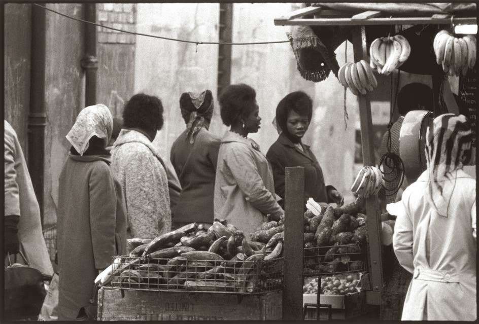 #16 West African women shop for fruits and vegetables in Brixton market, London.