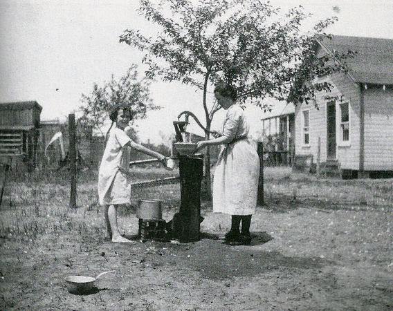 #8 Catherine Rehbein helping her daughter get a drink from the well in Union Beach.