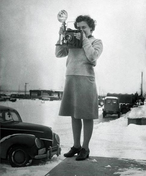 #19 United States Army Photographer lass using the sports finder frame of her Graflex camera.
