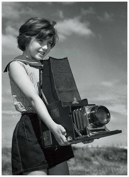 Maxine Sullivan, age 10, with her father’s large Graflex camera, at the beach of 1950’s Melbourne, Australia.