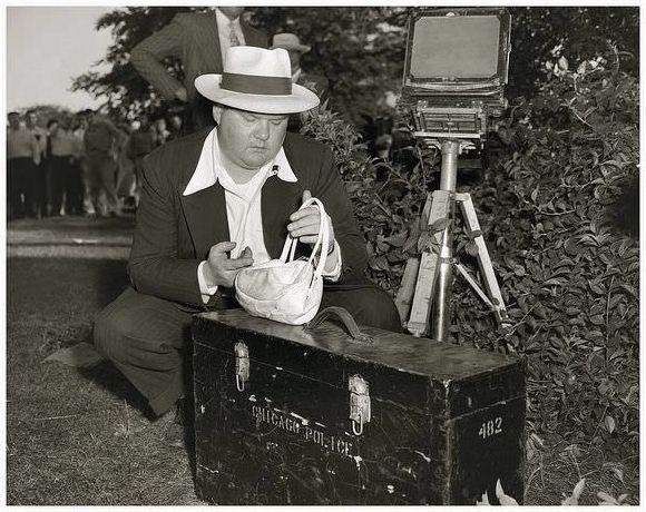 Detective Patrick O’Brien of the Chicago Police Crime Lab, records a major crime scene with his large format Ansco camera in June, 1950.
