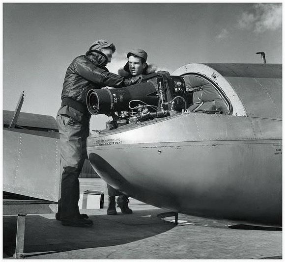 American Air Force photographers load a Fairchild K-22 camera into the nose of a reconnaissance aircraft.