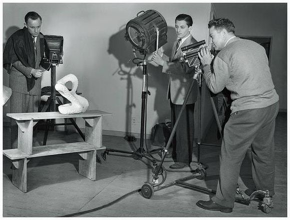 Chicago camera club photographers of the 1940’s pose it up for a snapshot. The guy on the left is using a large Korona stand camera, while the fellow on the right shoots with a Cine Kodak Special.
