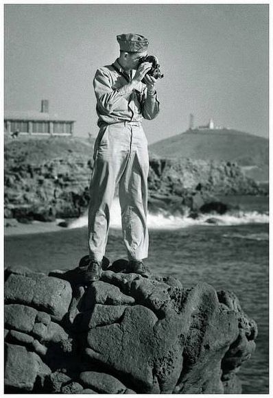 United States serviceman with a Bell &; Howell Eyemo movie camera.