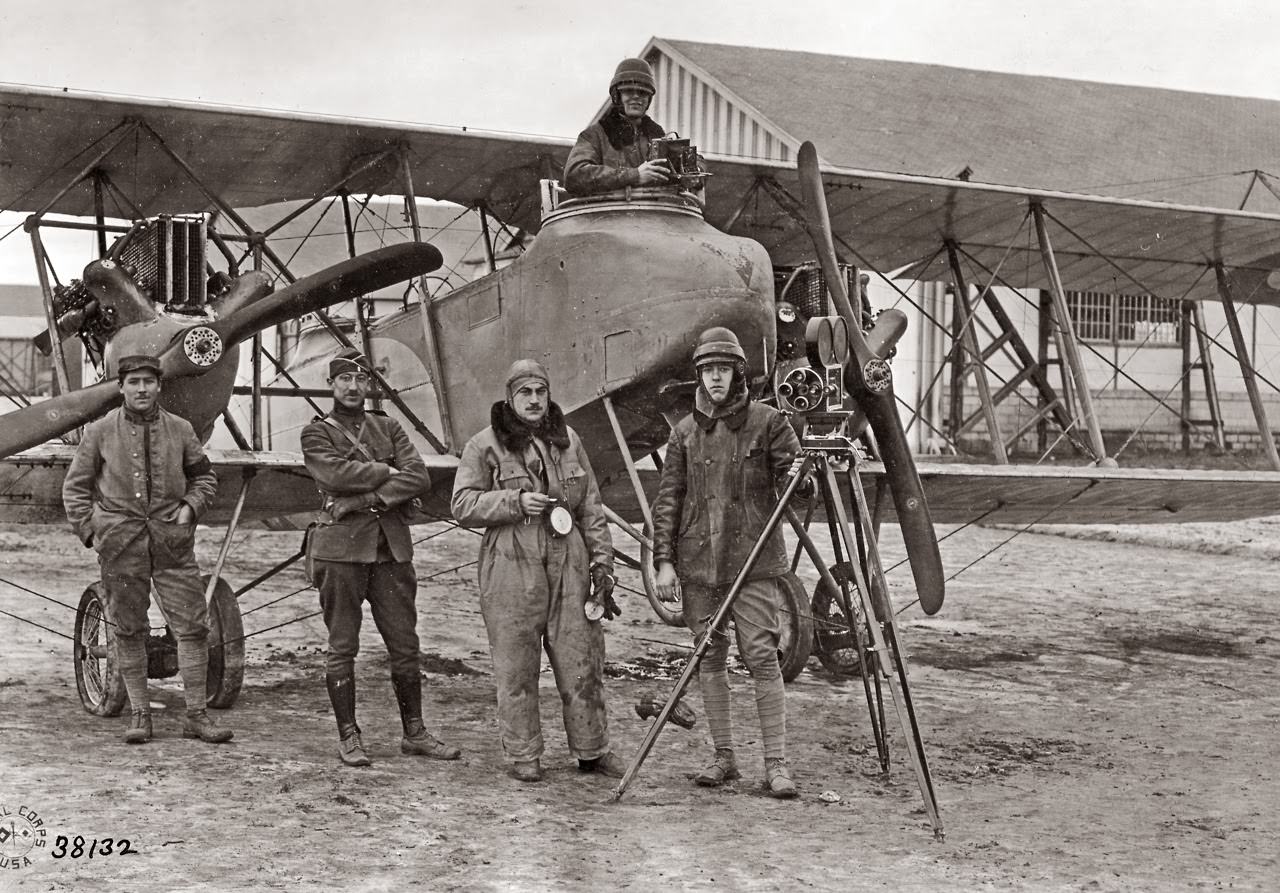 Photo Unit after making pictures: Lieut. Strohmeyer (in observer’s seat in plane) Sgt. A.J. Roach by movie camera; Lt. E.G. White, Signal Officer, French Sergeant-Pilot Geriet.