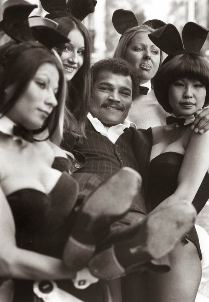 Champion British boxer John Conteh is lifted by Playboy Bunny Girls, 1974.