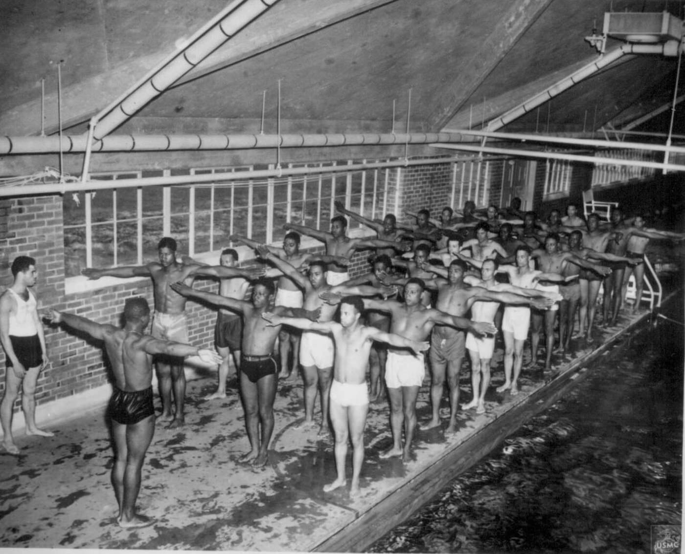 #18 Marine Pfc. Paul Tolliver instructs leathernecks on the correct movements for the breaststroke at Montford Point, Camp Lejeune, N.C., 1944.