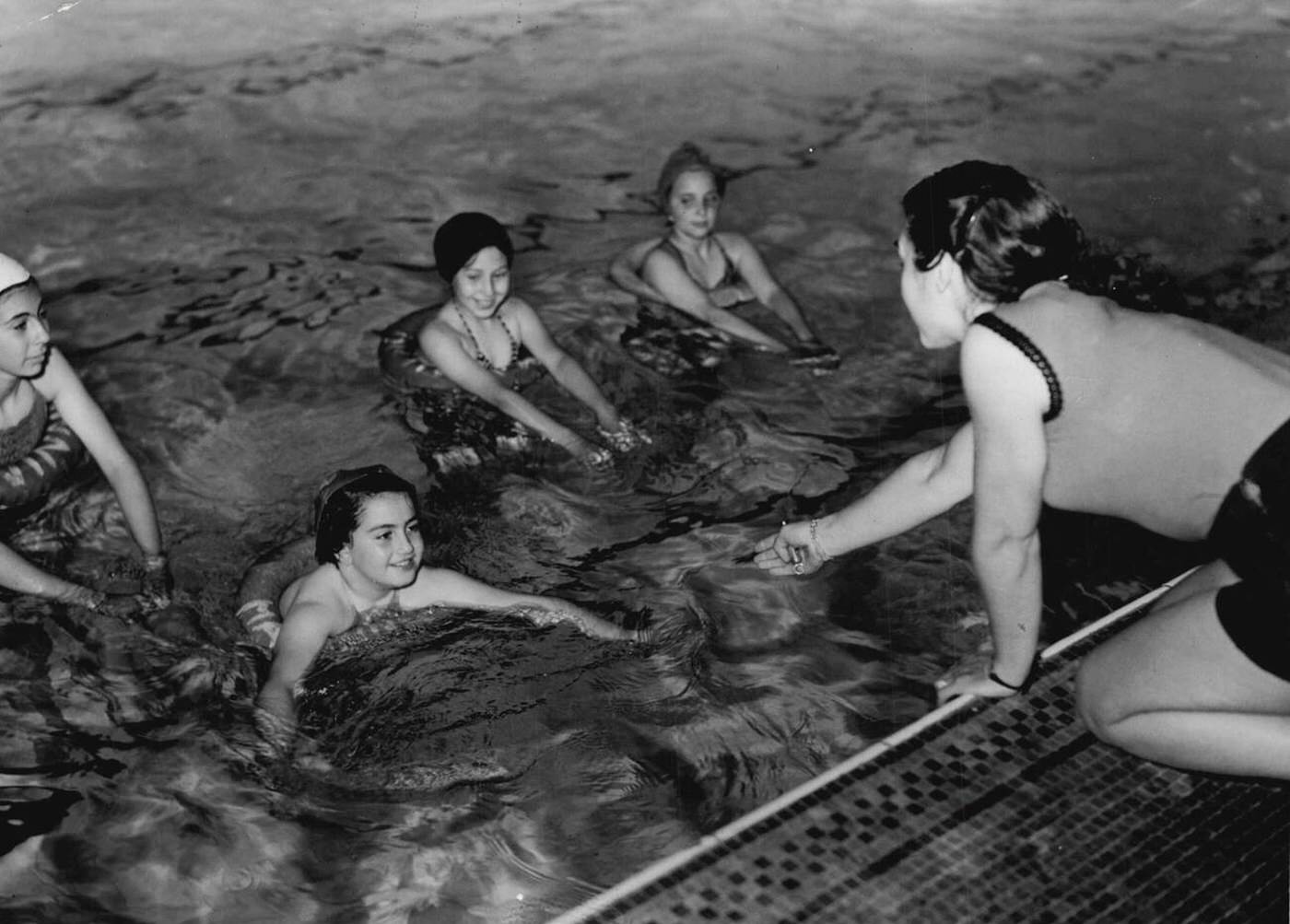 #19 Swimming classes at the Marshall street swimming baths, All Soul’s School, London; pictured left to right: Sybil Jacobvitch; Androulla Savva (Cypriot); Mary coutsarou (Cypriot); Betty Healey, 1952.