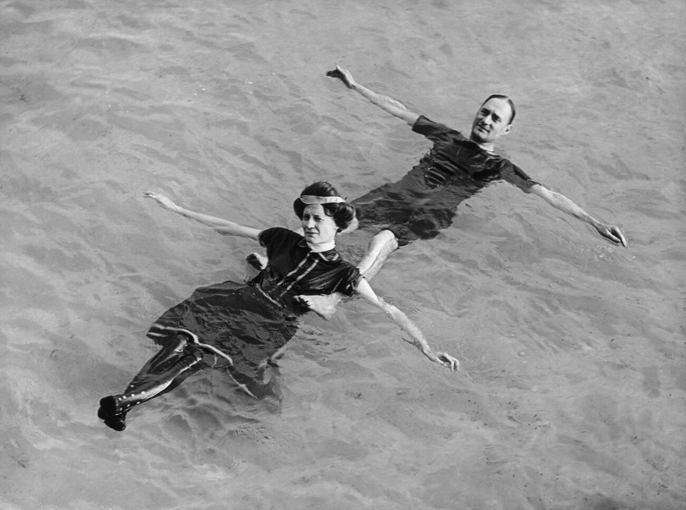 #23 Man and woman floating on their backs in water, 1900s.