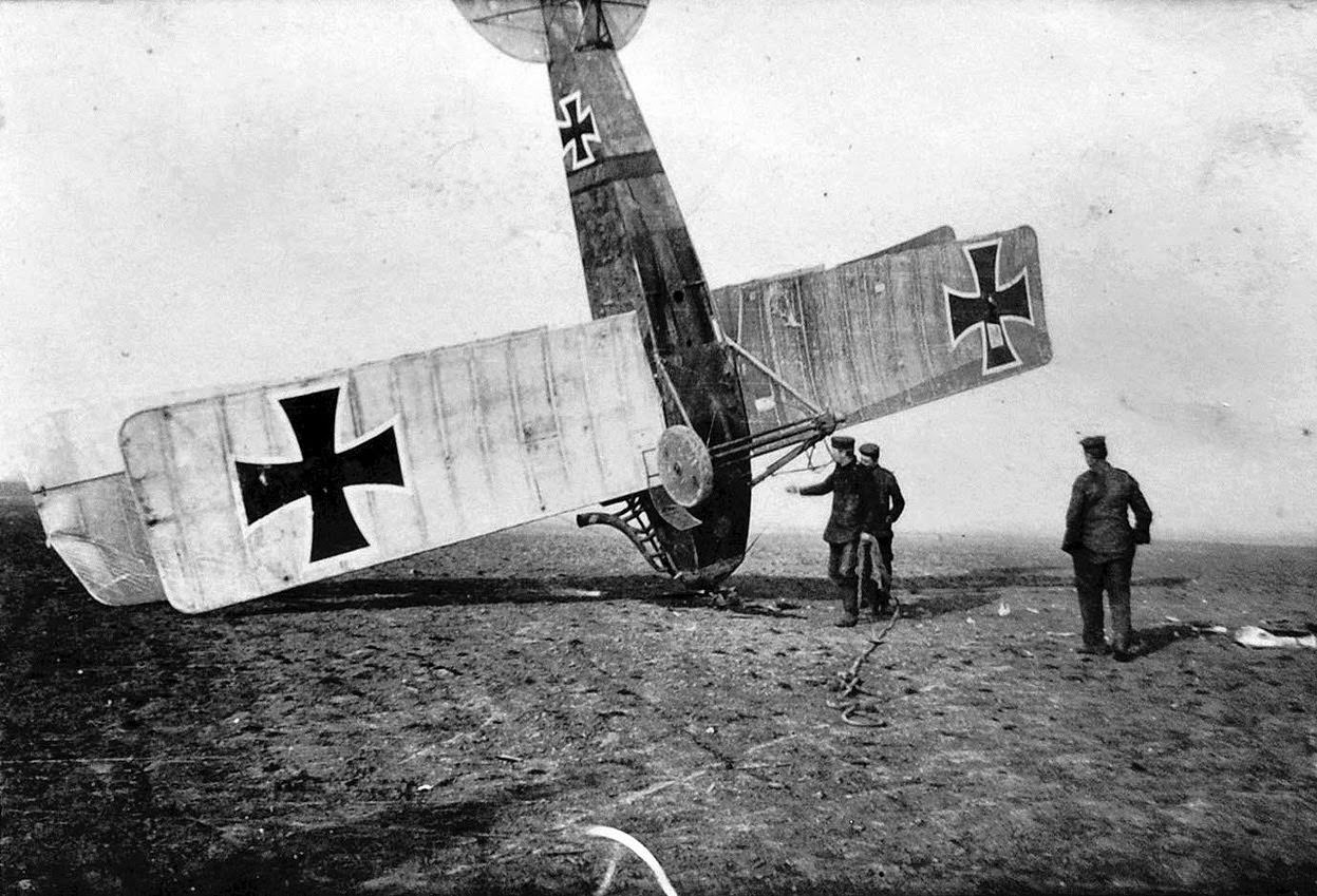German soldiers attend to an upended German aircraft.